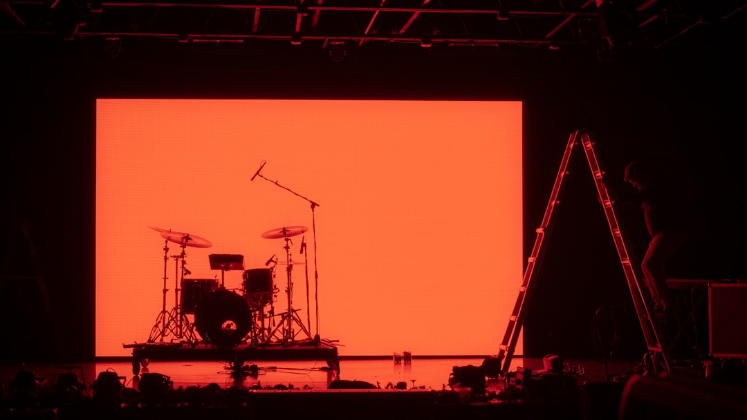 Drum set on stage with orange screen background